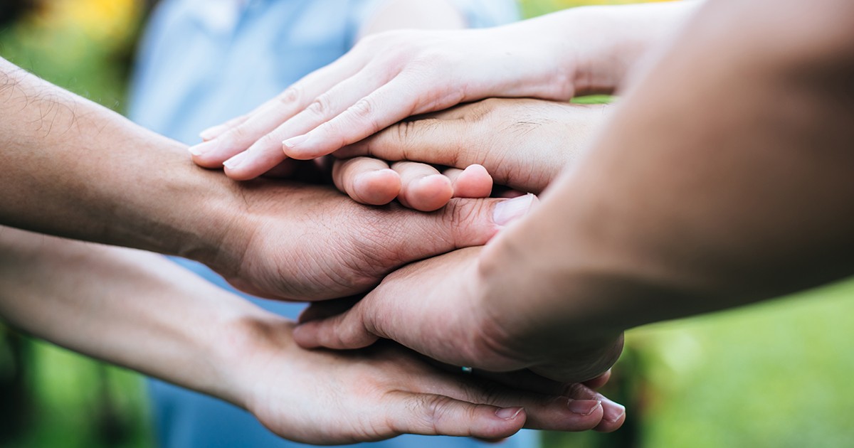 mains les unes sur les autres symbole de solidarité dans une association